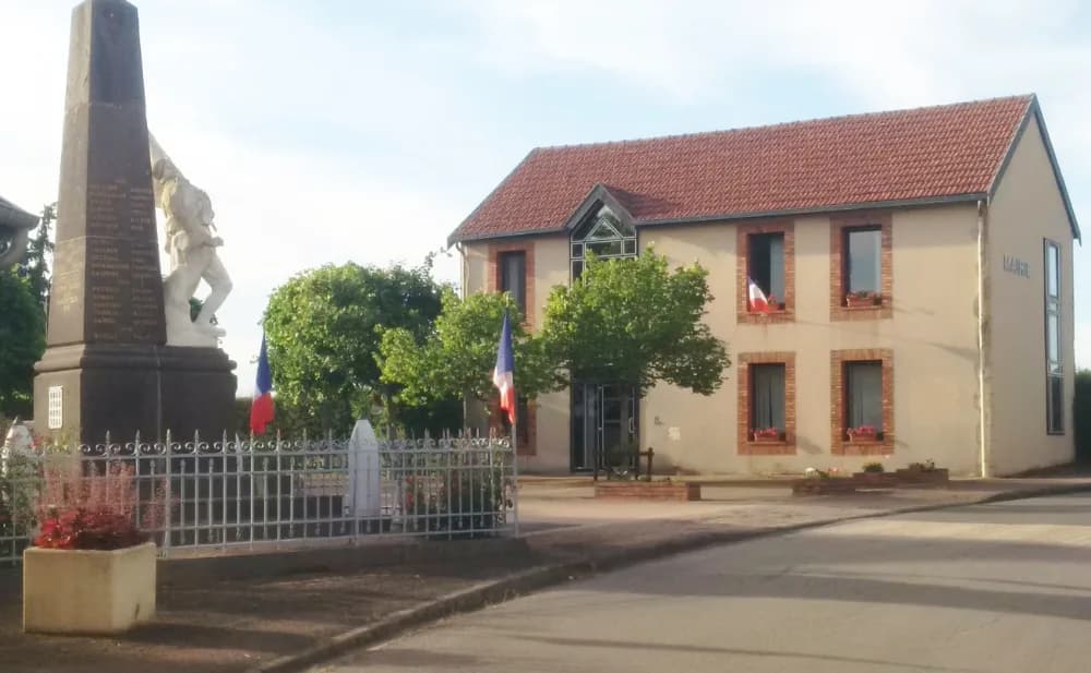 La mairie de La Crouzille et son monument aux morts pavoisé aux couleurs françaises